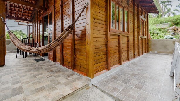 A wooden cabin with a hammock, tiled floor, and a view of greenery. - Casa p 5 Pessoas Perto das Praias e Beto Carrero (Penha)