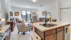 Eine moderne Küche mit Kochinsel, integrierten Geräten und einem Essbereich mit einer Couch und Sesseln.