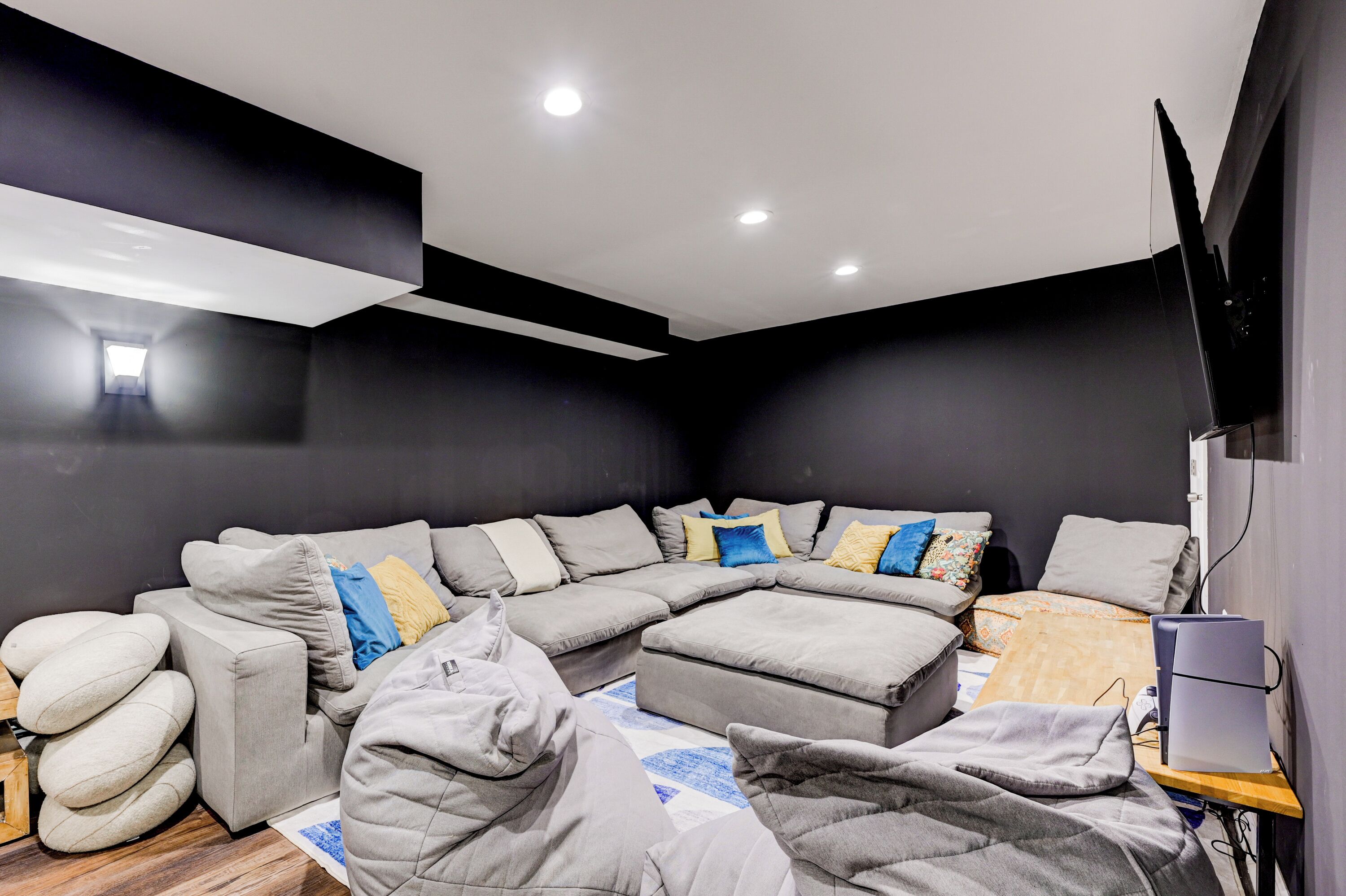 Una sala moderna con un sofá modular, un reposapiés y un televisor de pantalla plana.