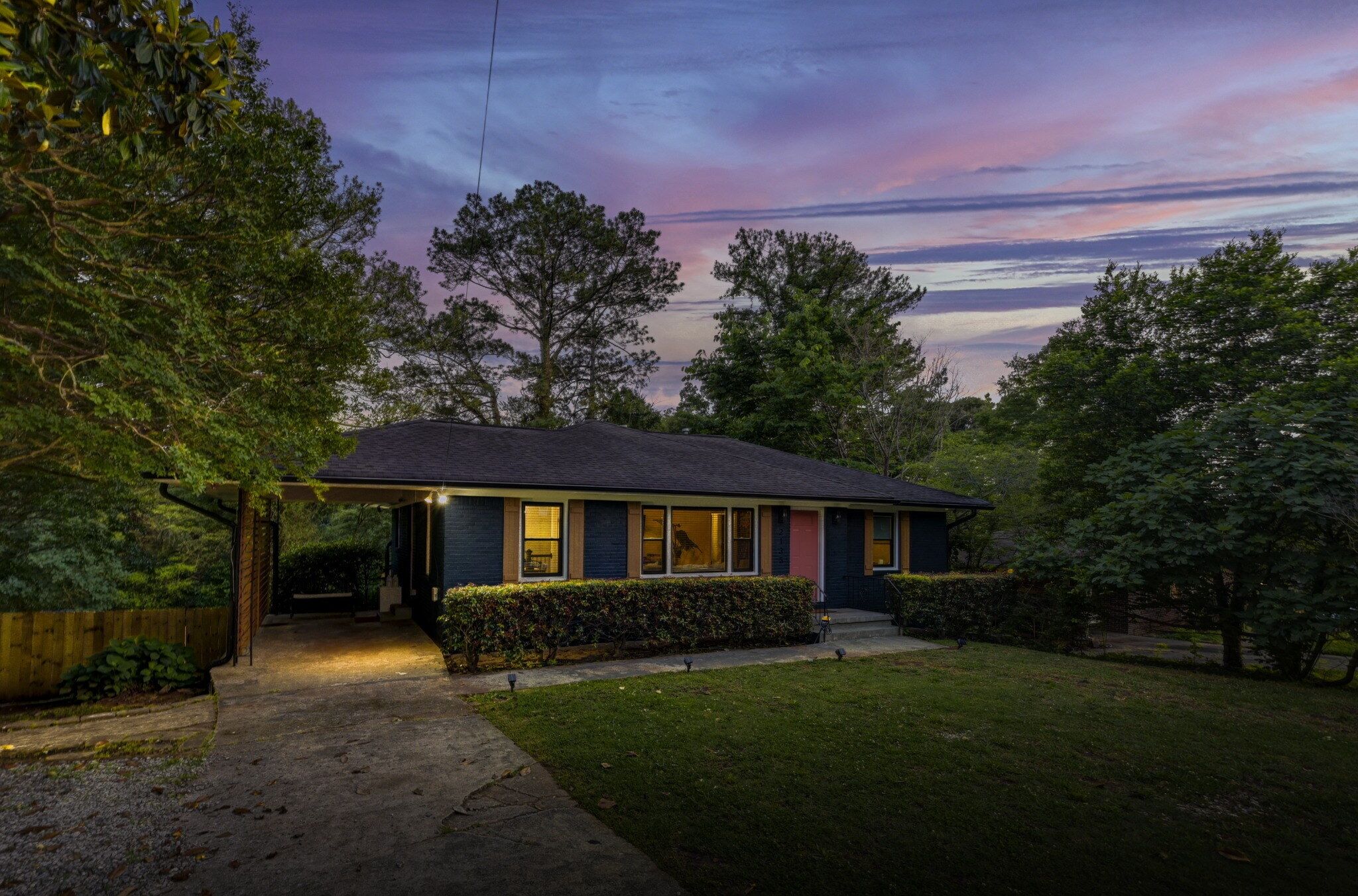 A single-story house with a covered porch, a well-maintained lawn, and a clear view of the sky.