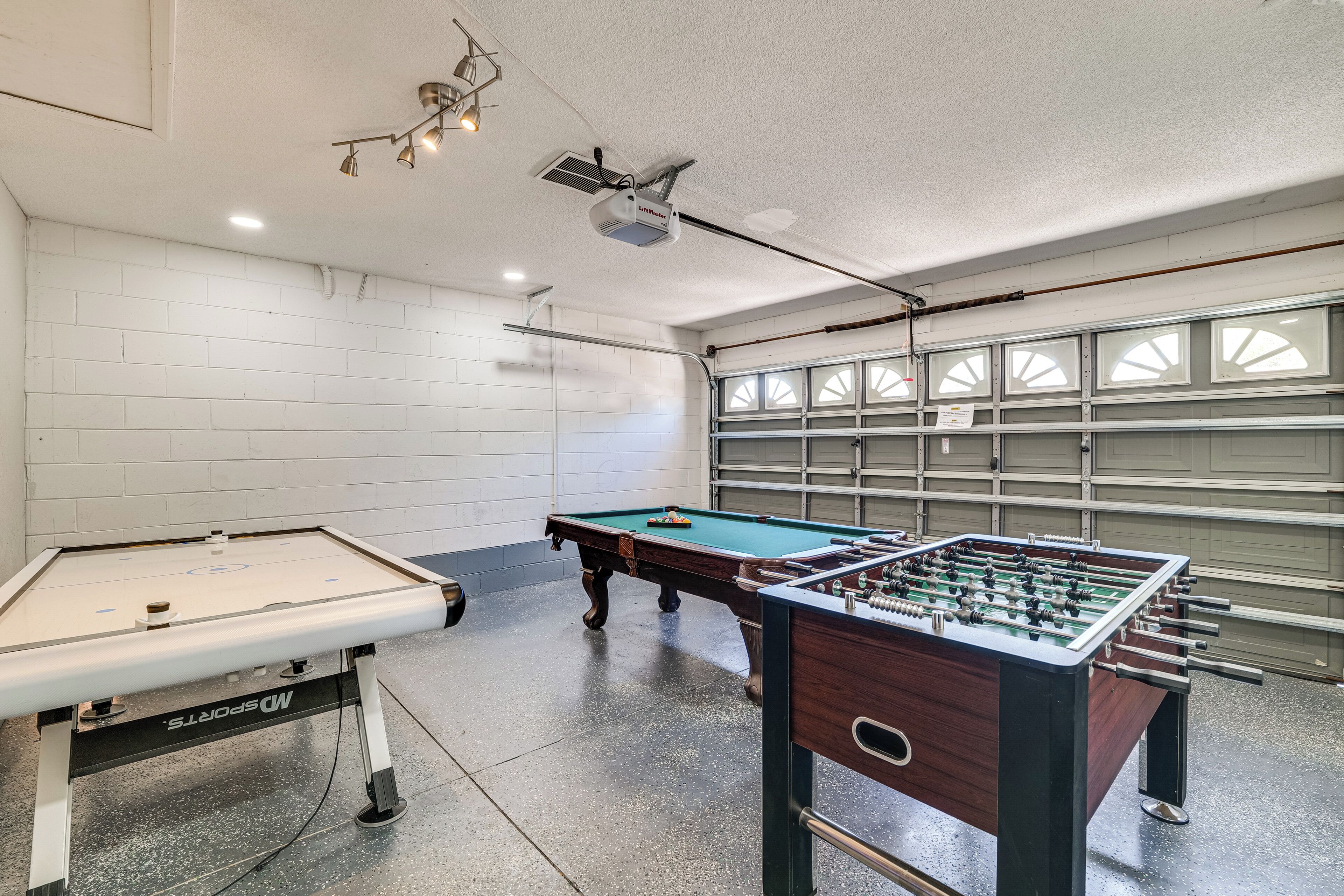 Ein Raum mit Billardtisch, Kicker und einem Projektor an der Decke.