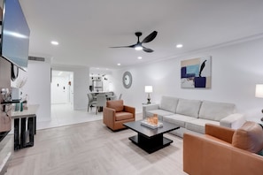 A modern living room with a sofa, armchairs, a coffee table, and a dining area in the background. - Old Town Oasis! Modern Unit w/ Resort-style Pool (Scottsdale)
