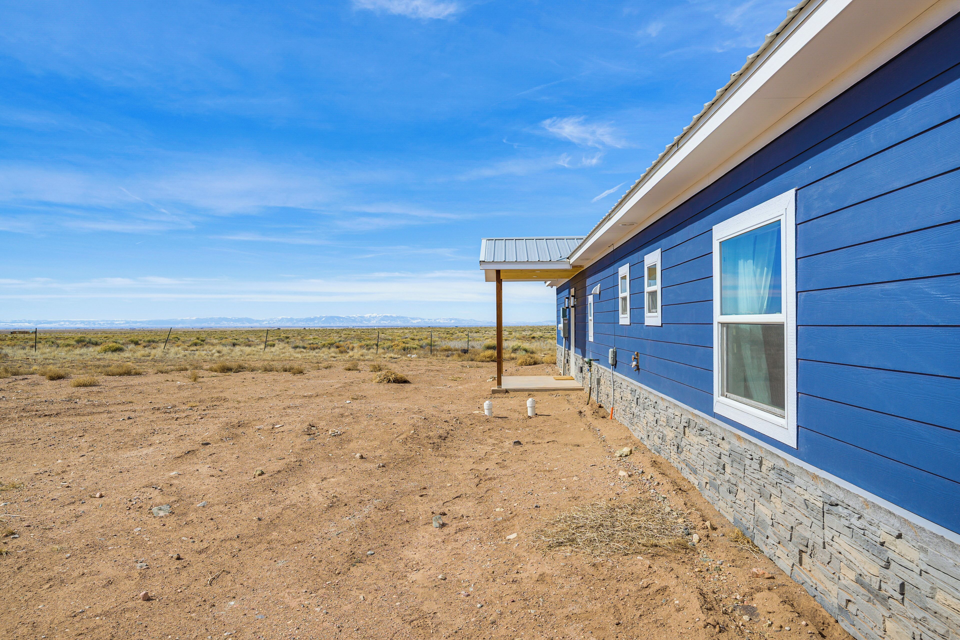 A blue house with a stone foundation and a covered porch.
