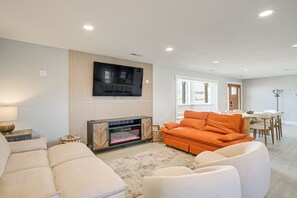 A modern living room with a fireplace, a sofa, and a dining area. - Sand Dunes Escape: Epic Stargazing! (Blanca)
