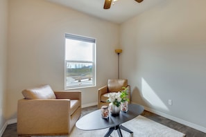 A room with a large window, two leather sofas, a black table with a vase and jars, and a floor lamp. - Near Powers Corridor & Bases! Spacious Family Home (Colorado Springs)