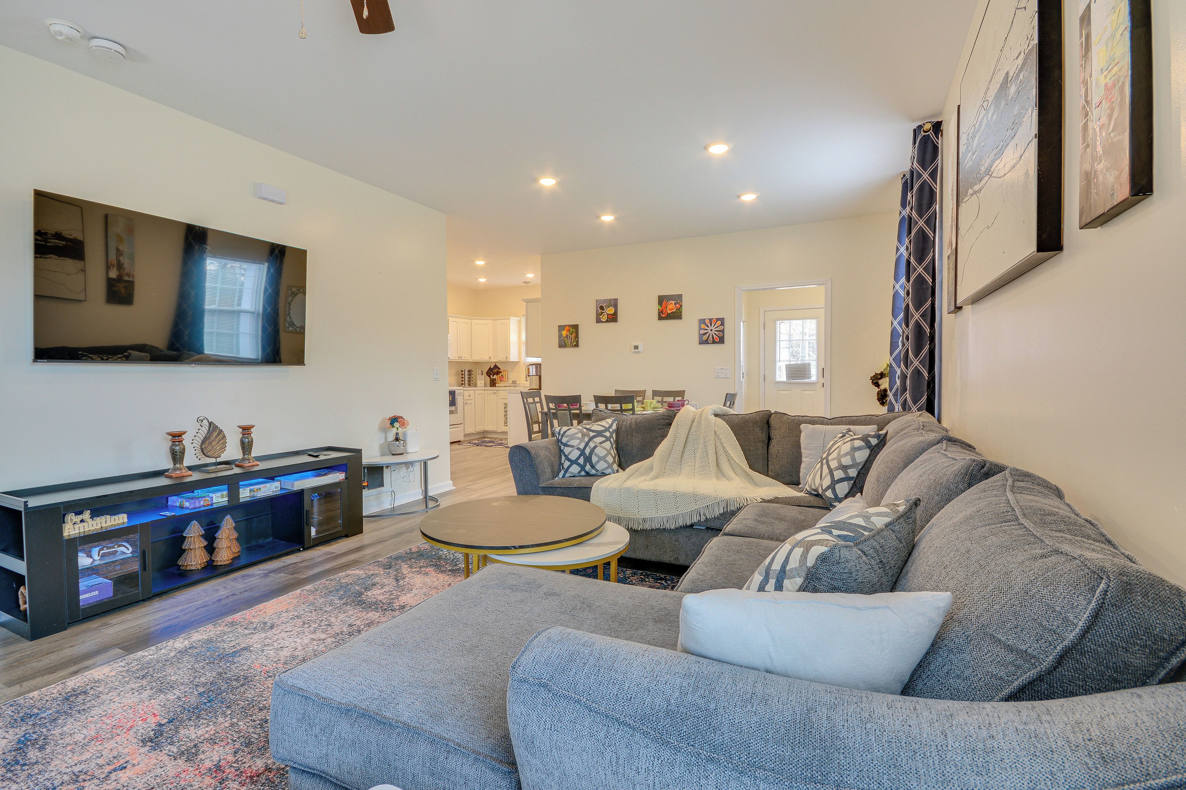 A modern living room with a grey sectional sofa, a coffee table, and a TV on a stand.