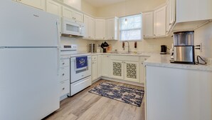 A kitchen with white cabinets, a built-in microwave, a stove, and a coffee maker. - 1 Mi to Downtown Greensboro: Newly Built Home! (Greensboro)