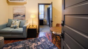 A living room with a sofa, a coffee table, a lamp, and a rug. - I-95 & I-20 Stopover: Walkable Florence Condo (Florence)