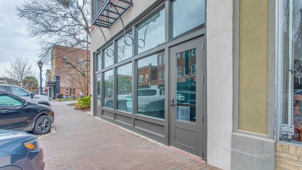 A building with large windows and a brick sidewalk. - I-95 & I-20 Stopover: Walkable Florence Condo (Florence)