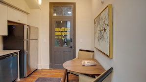 Une cuisine compacte équipée d’un réfrigérateur, d’un lave-vaisselle et d’une table à manger avec des chaises.