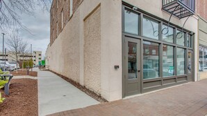 A building with a large glass door, a brick pathway, and a small garden area with plants. - Great for Med Professionals! Dtwn Florence Condo (Florence)