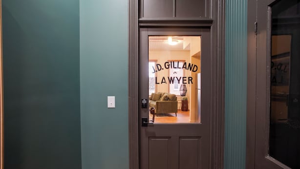 A door with a sign reading "J.D. GILLAND LAWYER" and a glimpse of a room with a sofa and a lamp. - Great for Med Professionals! Dtwn Florence Condo (Florence)