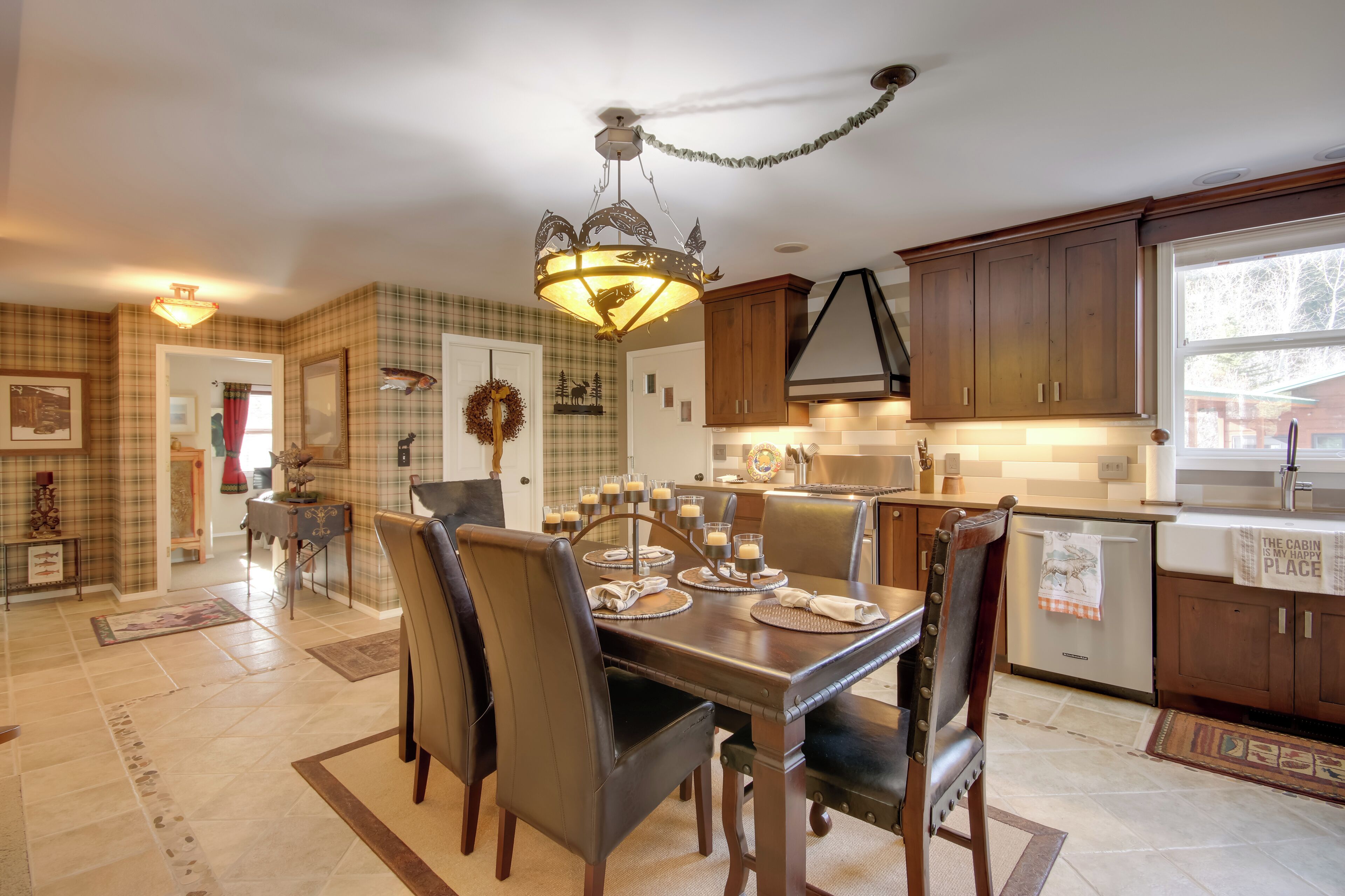 A dining area with a chandelier, wooden cabinets, and a view of the kitchen.