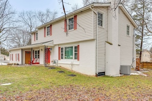 A two-story house with a front porch, a small front yard, and a visible chimney.