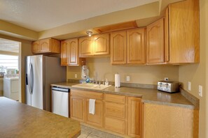 A kitchen with wooden cabinets, a stainless steel refrigerator, a dishwasher, a sink, and a toaster. - Near Ski Slopes & ATV Trails: Large Lead Getaway (Lead)