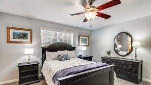 A bedroom with a bed, nightstands, a dresser, a ceiling fan, and framed pictures on the walls. - Lakefront Guntersville Base: Boat Parking & Power! (Scottsboro)
