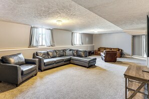 A spacious living room with a sectional sofa, a leather armchair, and a wooden coffee table. - Spacious & Family Friendly! Lincoln Home w/ Deck (Lincoln)