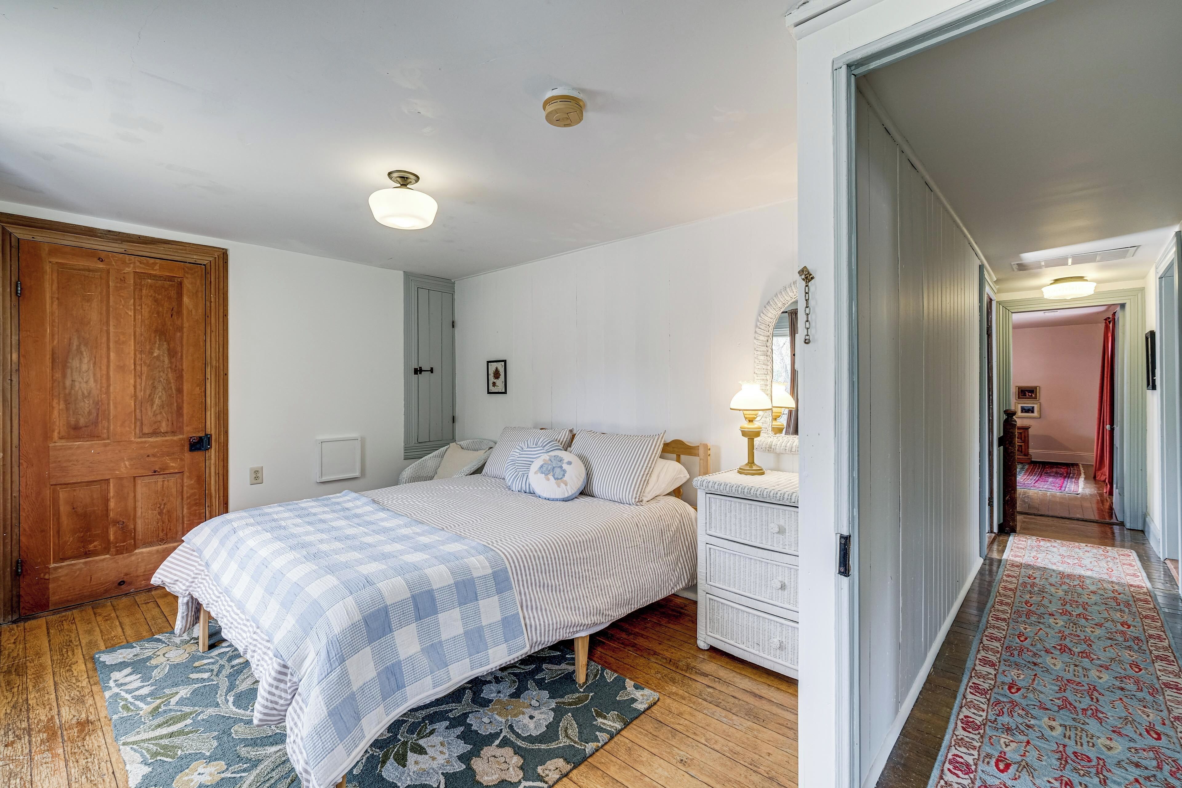 Una camera da letto con un letto, un comodino e una porta.