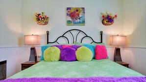 A bed with colorful pillows, two wall-mounted flower baskets, and a painting above the bed. - Peaceful Tiny Home Getaway Near Bowie Trade Days (Bowie)
