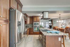 Eine moderne Küche mit Edelstahlgeräten, Holzschränken und einer Arbeitsplatte aus Granit.