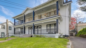 A two-story house with a front porch, a balcony on the second floor, and a garage.