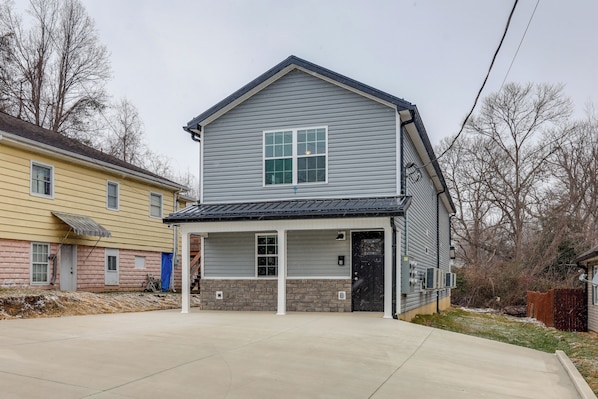 A two-story house with a covered porch and a garage.