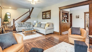 A spacious living room with a wooden staircase, a fireplace, and a large wooden bookcase. - Gateway to PA Wilds: Brockport Family Home! (Brockport)