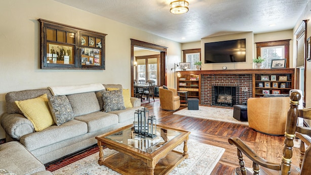 A cozy living room with a sofa, coffee table, and fireplace. - Gateway to PA Wilds: Brockport Family Home! (Brockport)