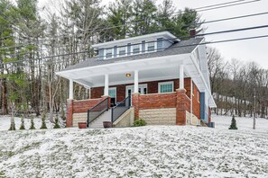 A two-story house with a covered porch, brick exterior, and a small staircase leading to the entrance. - Gateway to PA Wilds: Brockport Family Home! (Brockport)
