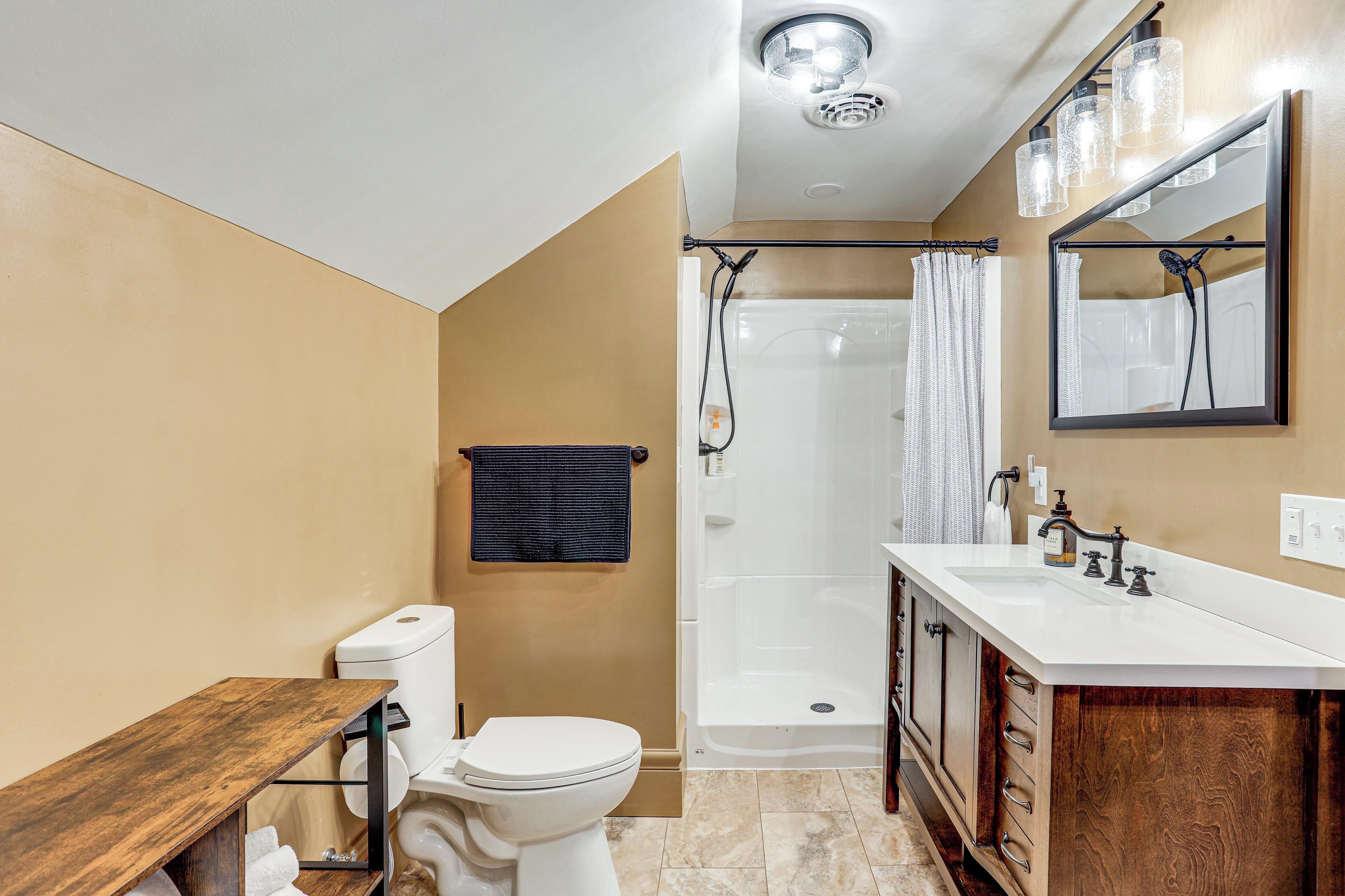 Ein modernes Badezimmer mit Toilette, Waschbecken, Waschtisch und Dusche.