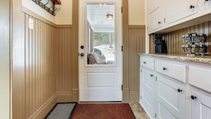 A kitchen with white cabinets, a wooden door, and a window with a view of the outside. - Gateway to PA Wilds: Brockport Family Home! (Brockport)