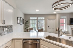 A modern kitchen with a large island, stainless steel appliances, and a dining area with a view. - Bright & Modern! Family Home 11 Mi to Dtwn Tacoma (Tacoma)