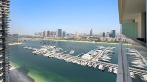 A marina with numerous boats docked, a city skyline in the background, and a high-rise building on the left. - Silkhaus Modern 1bdr Marina Vista Private Beach (Dubai)