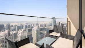 Un balcon doté de meubles en osier et offrant une vue dégagée sur le paysage urbain.