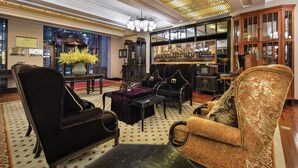 Un'ampia hall con arredi classici, un grande lampadario e un soffitto decorato.