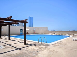 A rooftop pool with a clear view of a tall building in the background. - Silkhaus 2bdr in Julphar Tower Near Reem Park (Abu Dhabi)