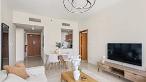 Ein modernes Wohnzimmer mit Sofa, Couchtisch, Fernseher und Essbereich.