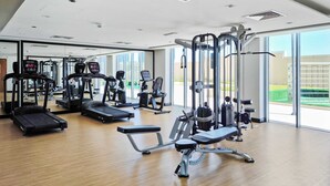 Ein modernes Fitnessstudio mit verschiedenen Trainingsgeräten, großen Fenstern und einem sauberen, geräumigen Design.