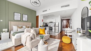 A modern hotel room with a large bed, a sofa, a dining table, and a kitchen area. - Silkhaus Lux Studio Binghatti Pearl Near Mall (Dubai)