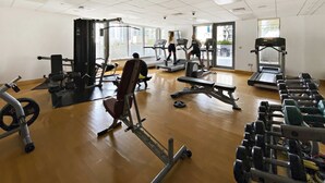 A gym with treadmills, weight machines, and free weights. - Silkhaus Luxury 1BR Emaar Near Burj Khalifa (Dubai)