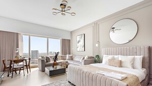 A spacious bedroom with a large bed, a sofa, a dining area, and a view of the city. - Silkhaus Gate Tower Luxurious Studio w City View (Abu Dhabi)