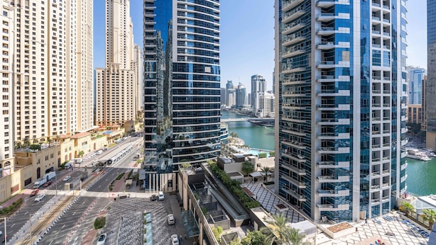 A high-rise urban area with modern buildings, a river, and a pedestrian walkway. - Silkhaus Dubai Marina Studio Bay Central Tower (Dubai)