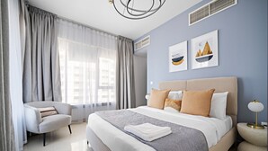 A modern bedroom with a large bed, a chair, and artwork on the wall. - Silkhaus Modern 1BR 29 Blvd Heart of Downtown (Dubai)