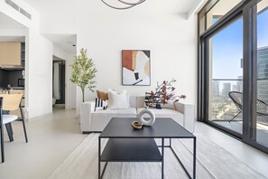 Ein modernes Wohnzimmer mit einem schwarzen Couchtisch, einem weißen Sofa und einem großen Fenster mit Blick auf die Stadt.