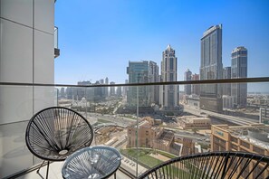 Ein Balkon mit Blick auf die Stadt, der moderne Gebäude und einen klaren Himmel zeigt.