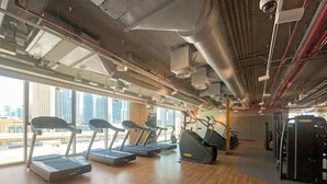 A gym with treadmills, elliptical machines, and weight equipment. - Silkhaus Stylish 2BR Downtown Views II Emaar (Dubai)