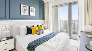 A modern hotel room with a large bed, a nightstand, a desk, and a balcony with a view. - Silkhaus Stylish 2BR Downtown Views II Emaar (Dubai)