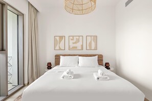 A modern hotel room with a large bed, a wicker headboard, and three abstract wall art pieces. - Silkhaus Big 2BR Downtown Views II Emaar Tower (Dubai)