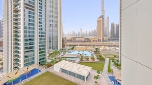 A high-rise residential building with multiple balconies, a swimming pool, and a view of the Burj Khalifa. - Silkhaus Big 2BR Downtown Views II Emaar Tower (Dubai)