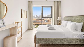 A hotel room with a large bed, a view of the city, a wooden side table, and a mirror. - Silkhaus Big 2BR Downtown Views II Emaar Tower (Dubai)